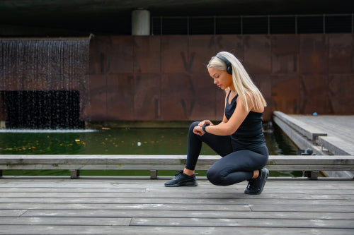 Beautiful fitness woman using smart watch phone