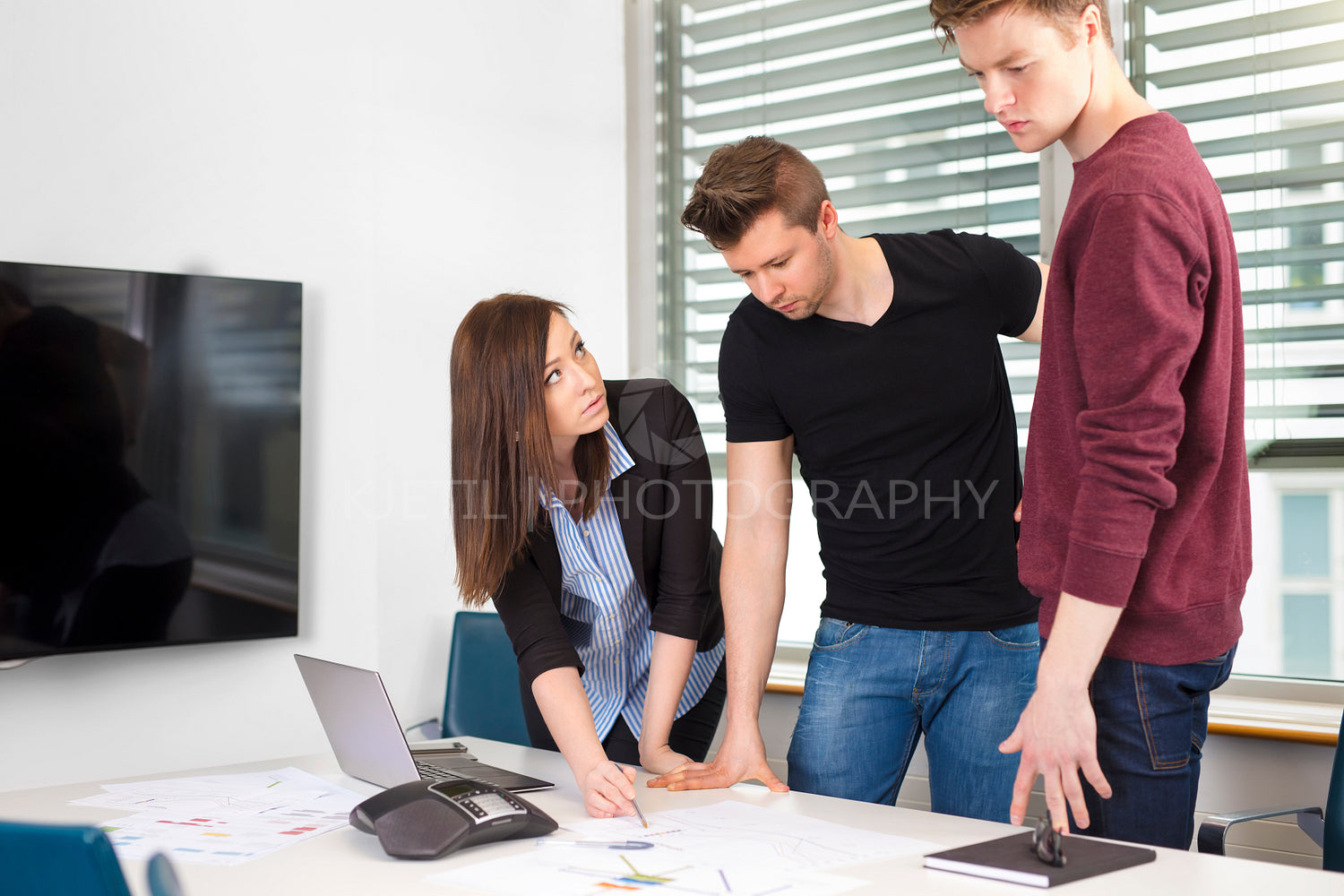 Businesswoman Explaining Plan To Coworkers At Desk