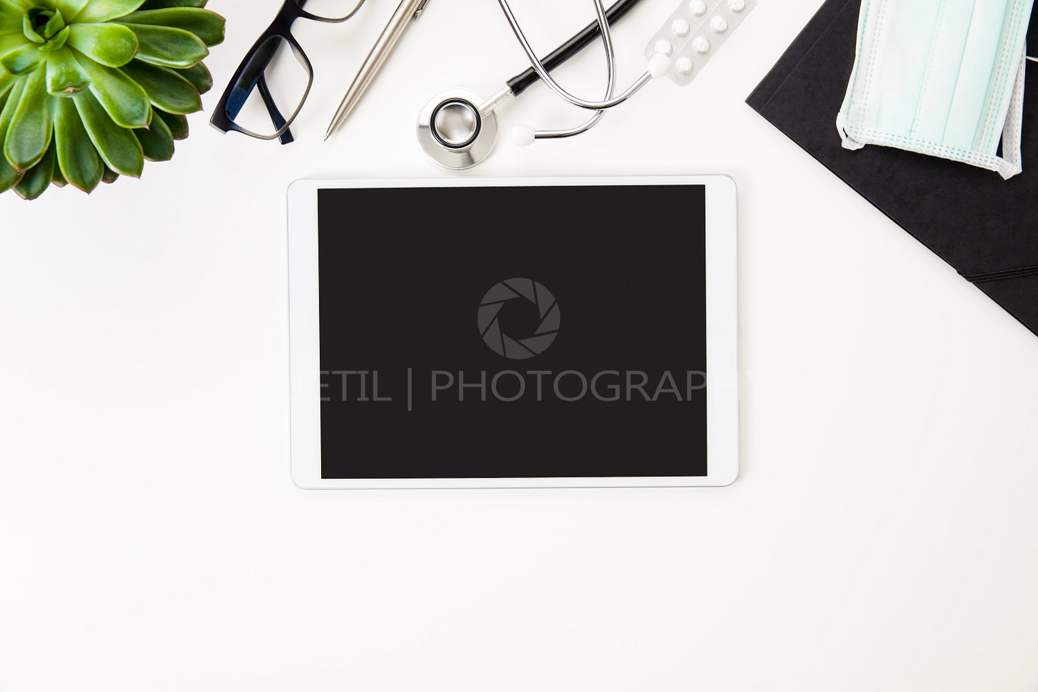 Digital Tablet Surrounded By Medical Equipment By Plant On Table