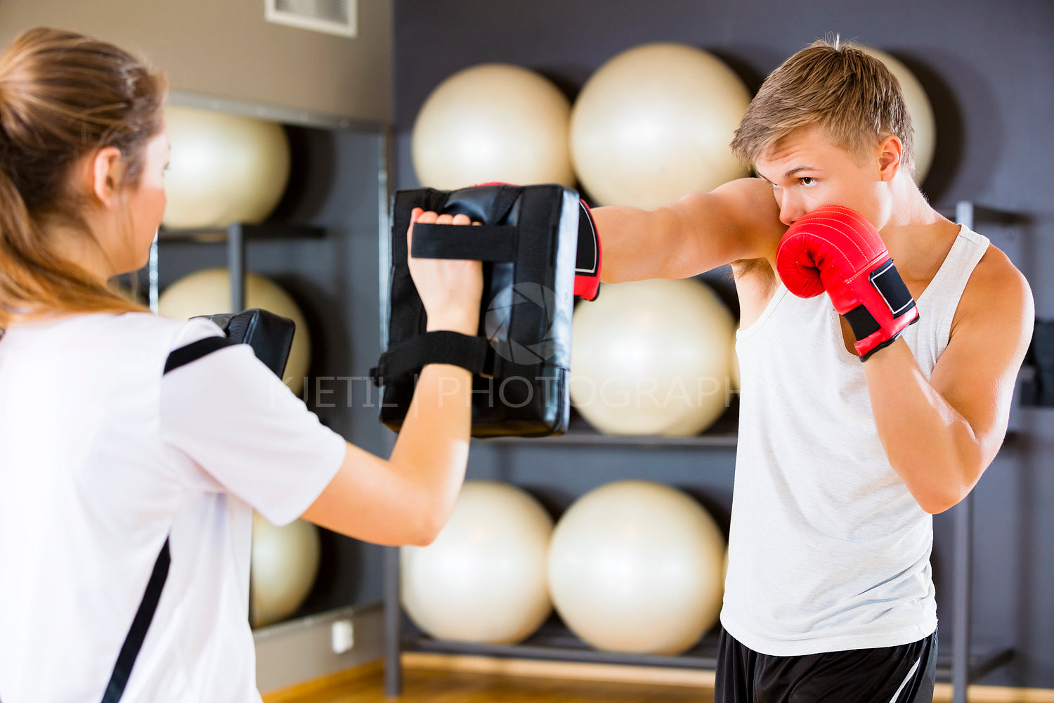 Dedicated Boxer Punching Bag Held By Instructor