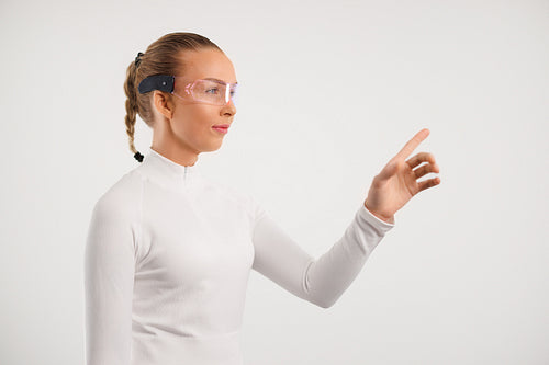 Female wearing virtual reality smartglasses in white room