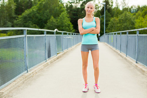 Confident and smiling young female runner having break after workout