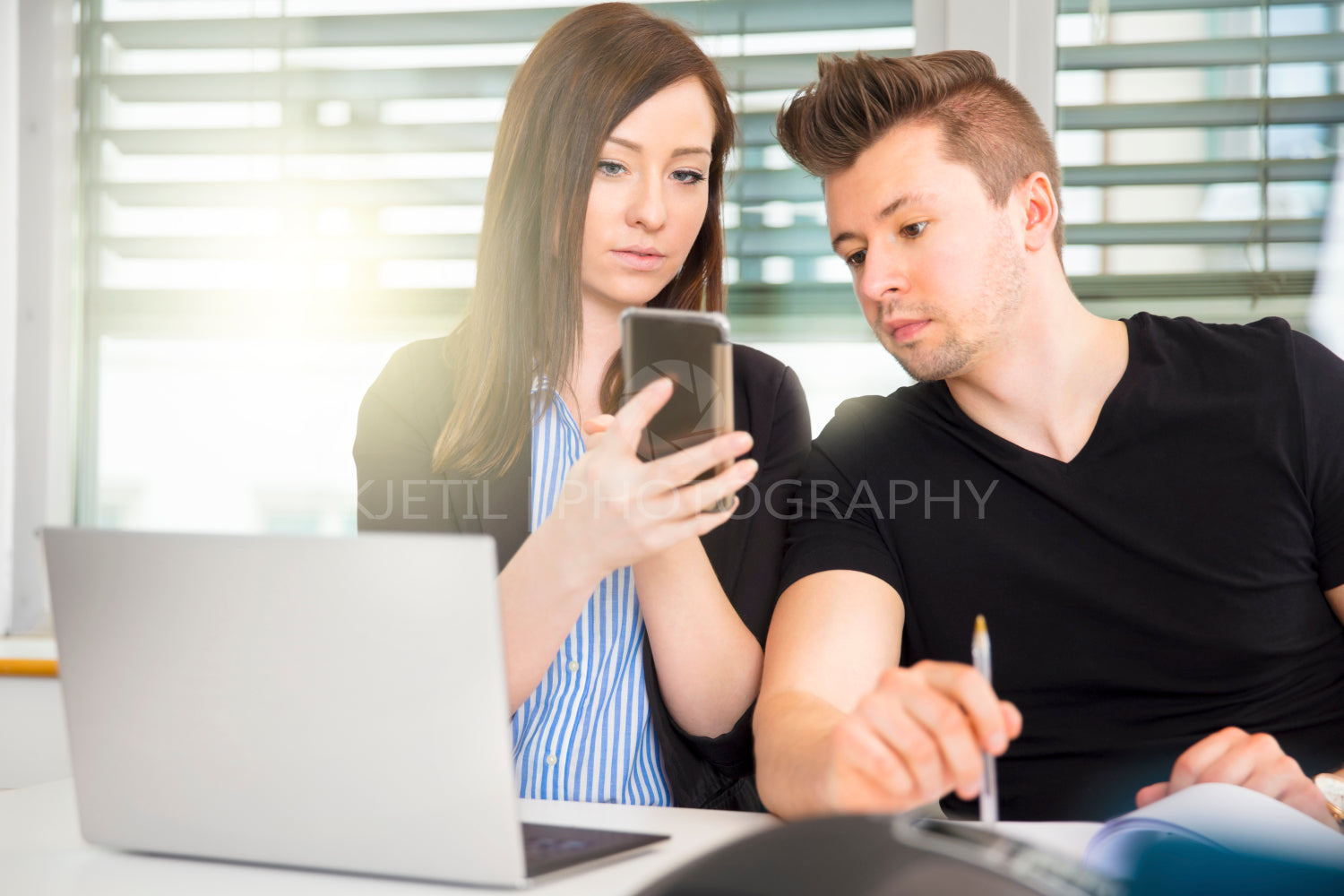 Business People Using Smart Phone At Desk In Office