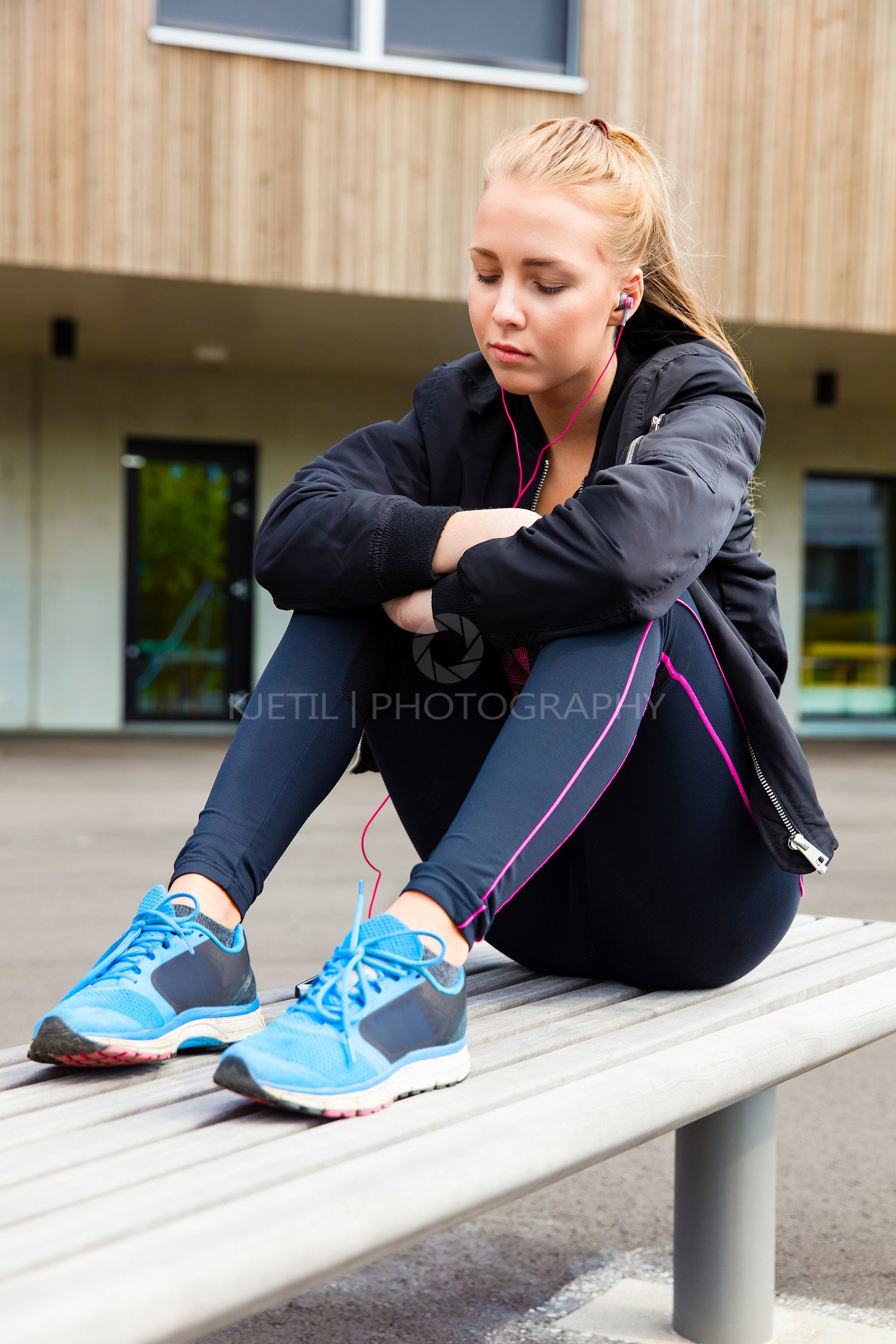 Relaxed Woman In Sportswear Listening To Music On Bench