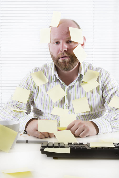 Exhausted Office Worker with Notes Everywhere