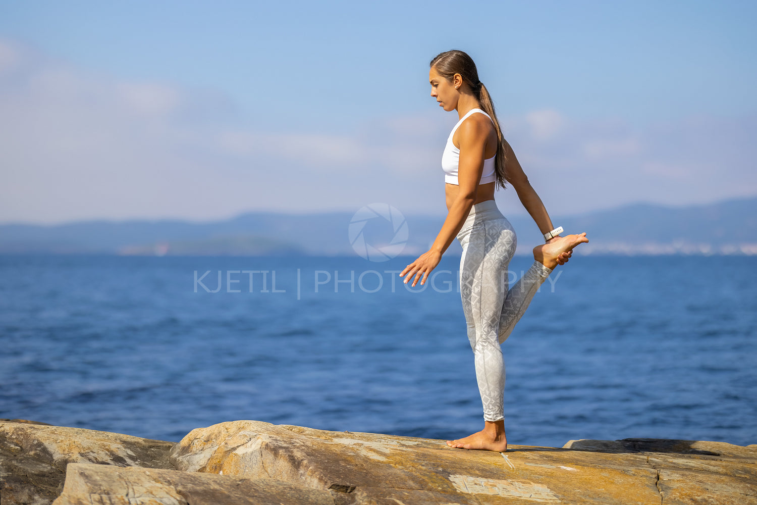 Slim Athletic Woman In Yoga Pose On Rock