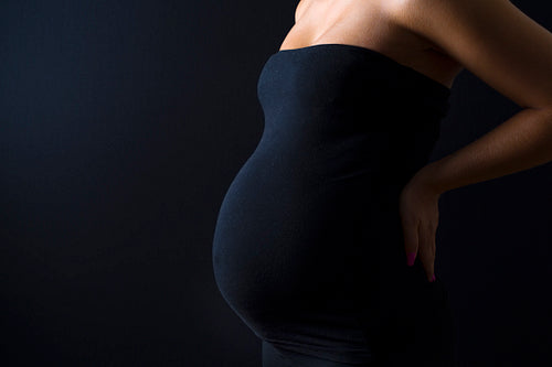 Beautiful pregnant woman with hands on her back