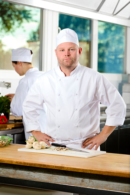 Confident chef standing in large kitchen
