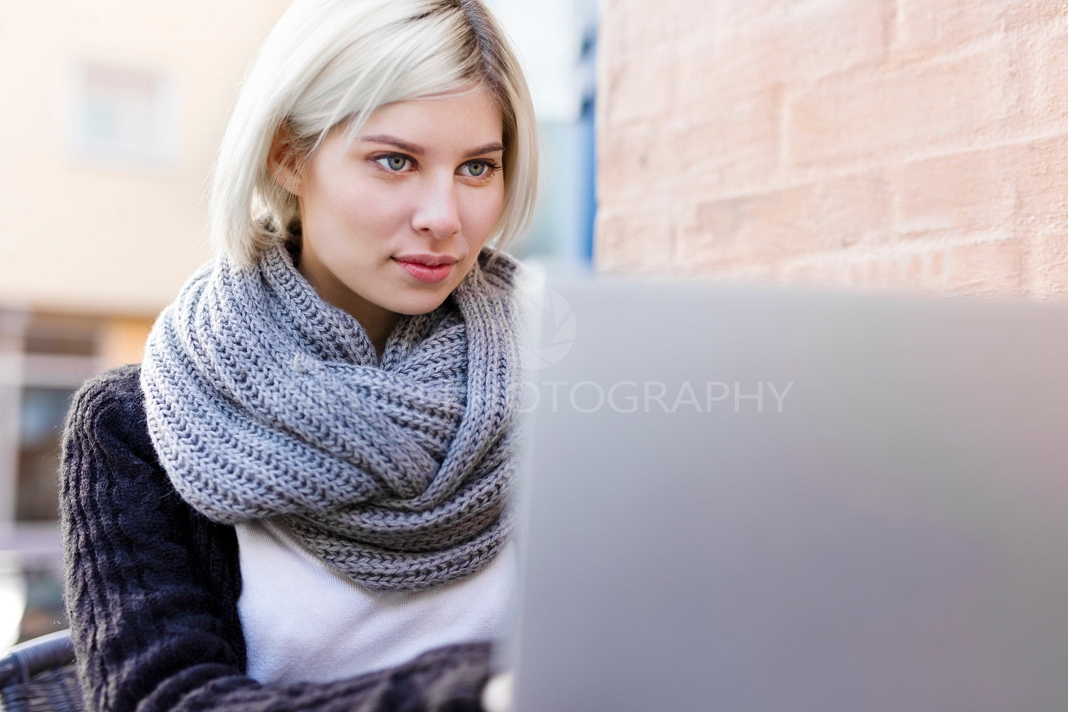 Focused woman working with laptop outdoor at cafe