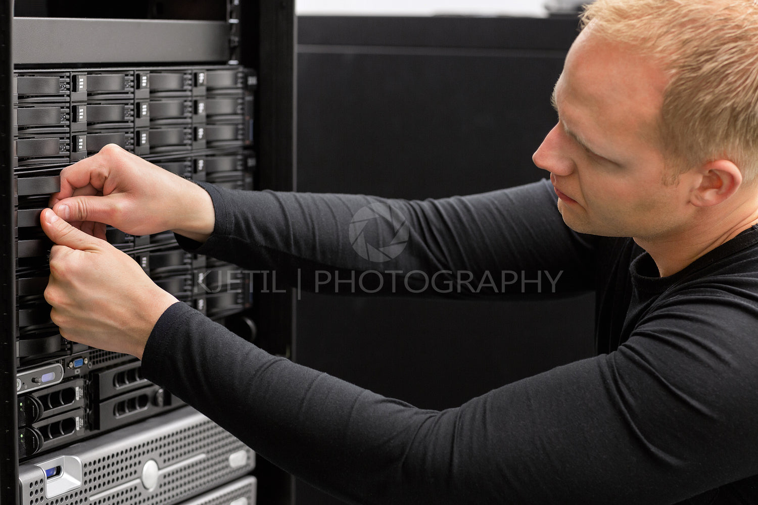 Male Technical Consultant Adjusting Hard Drives In SAN At Datace