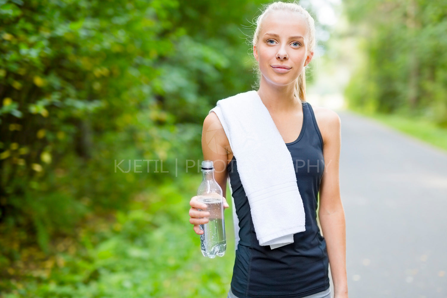 Smiling young woman having her break after running