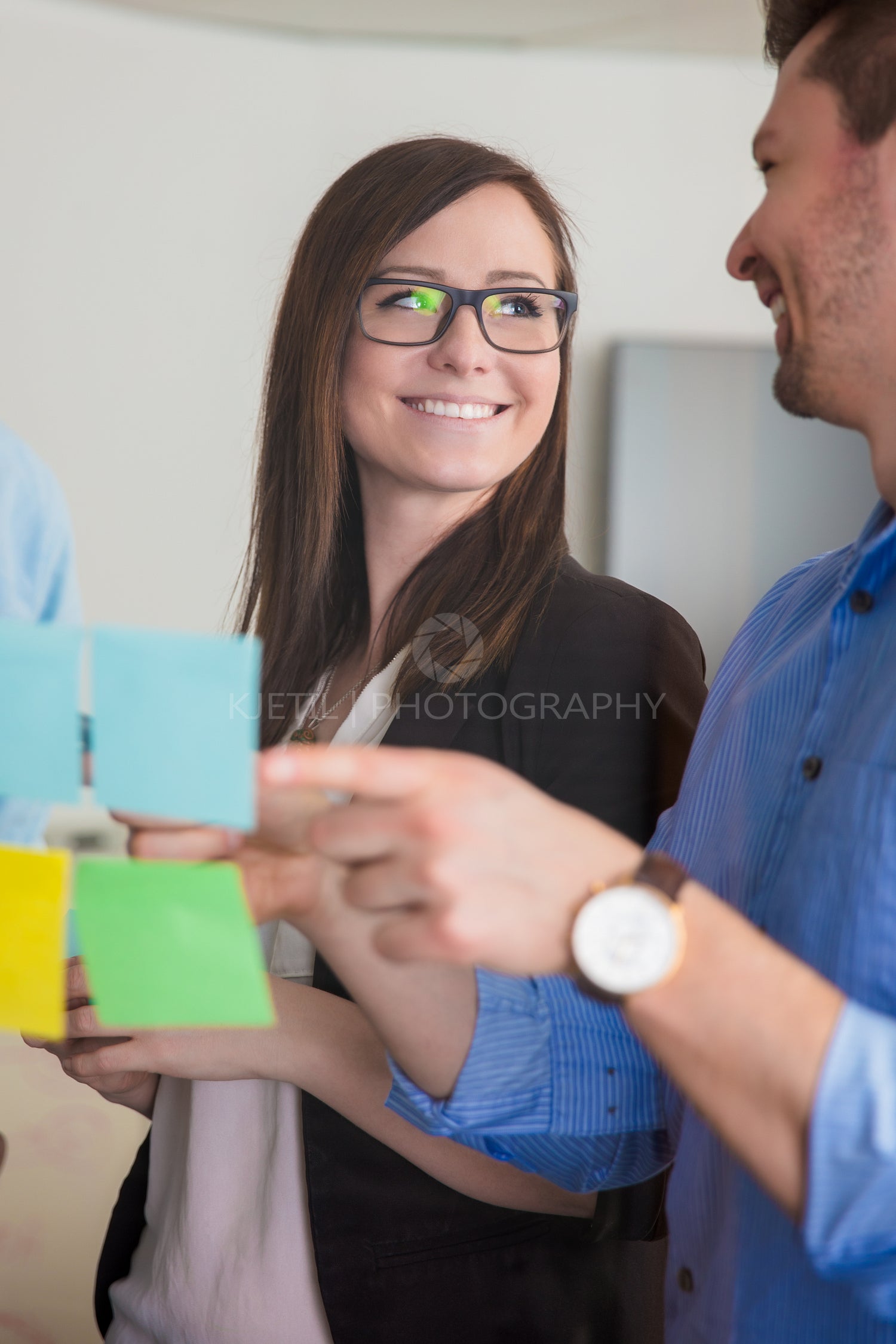 Businesswoman Looking At Colleague While Discussing Over Notes O