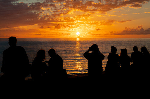Silhouette of People Enjoying Beautiful Sunset Over Open Sea