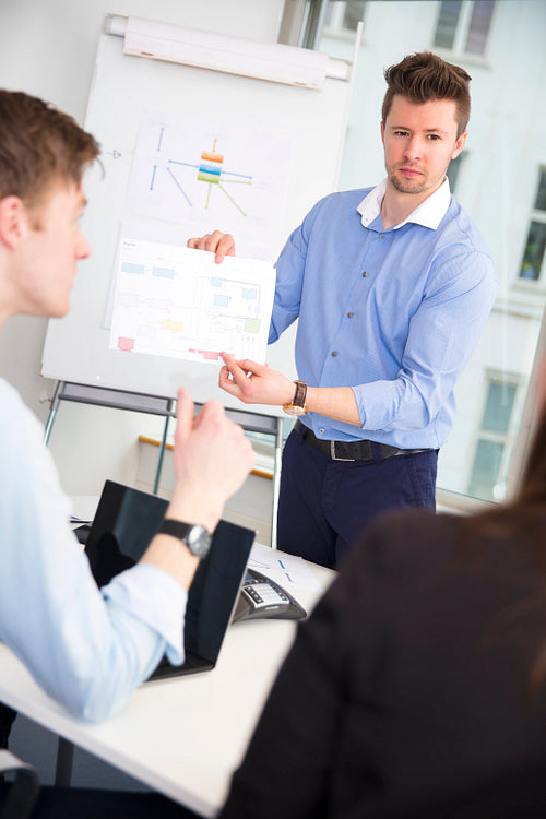 Confident Professional Showing Chart To Colleagues