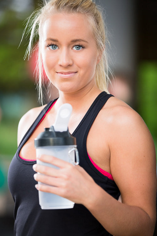 Young blonde woman drink water at fitness center