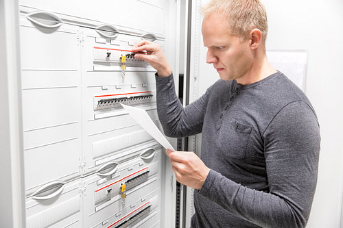 IT engineer works in large fuse cabinet