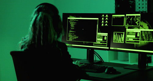 Cyber security hacker code malware to exploit vulnerability in program or system on a computer in a dark room