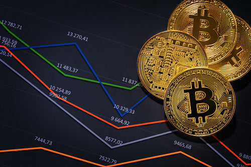 Close-up of gold bitcoin coins on financial charts for cryptocurrency prices