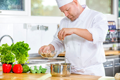 Professional chef preparing dish in large kitchen