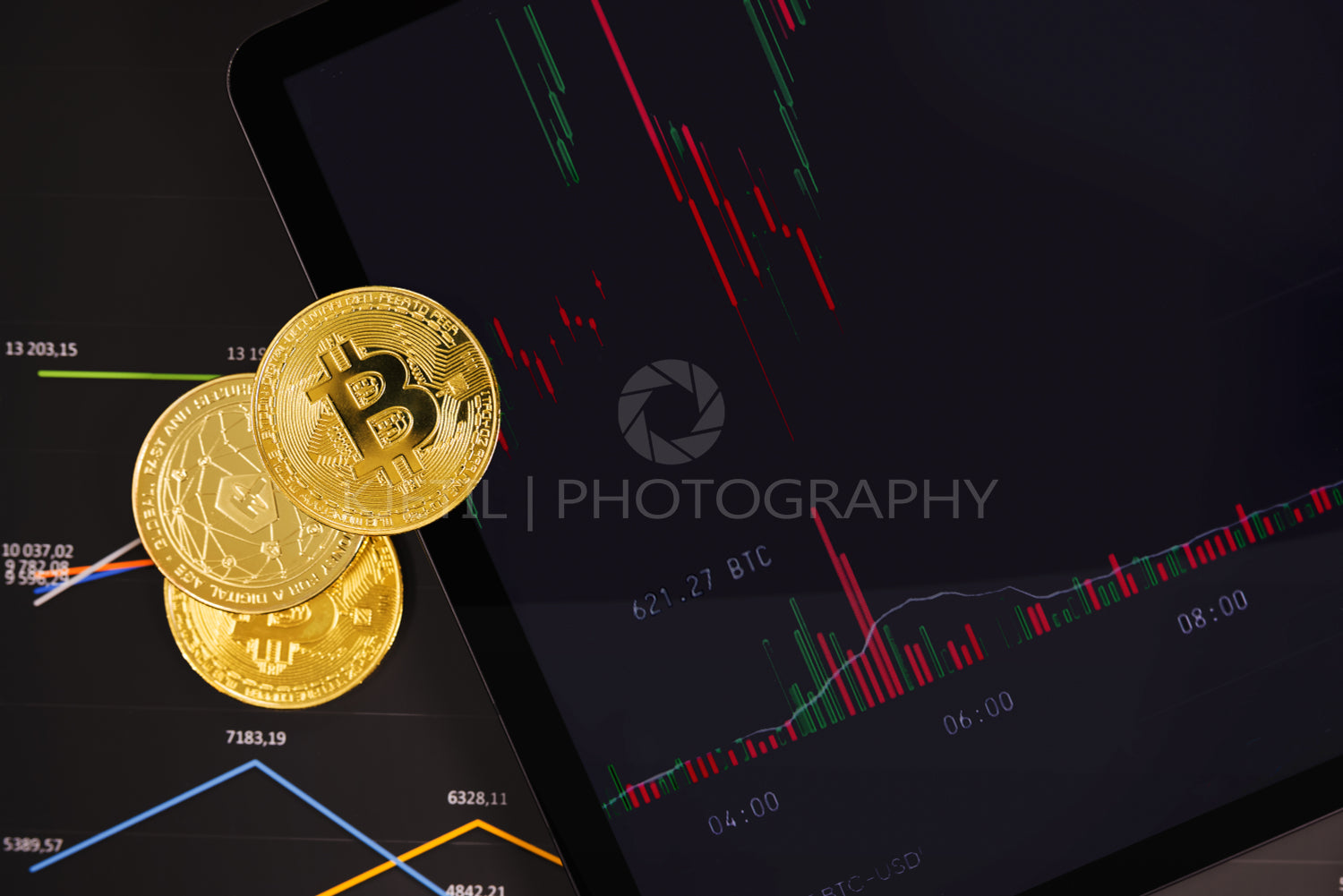 Bitcoin and Tether USDT coins on financial charts on a tablet sceen for crypto currency prices