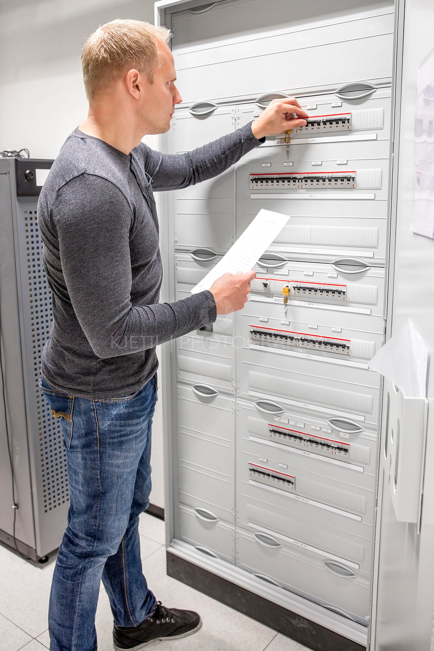 IT engineer works in large fuse cabinet