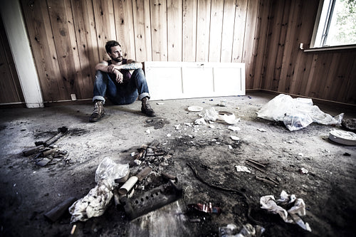 Rocker sits and smokes in abandoned house