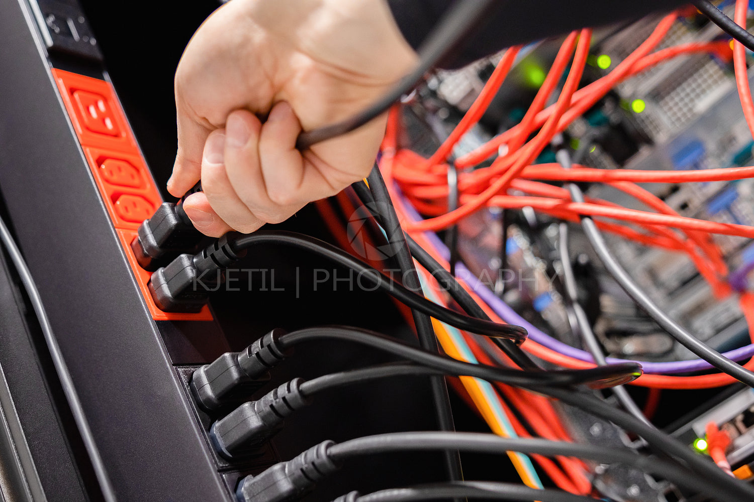 Male IT Engineer Removing Power Cable From Outlet in Datacenter
