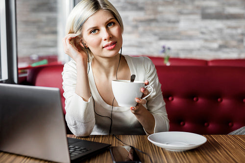 Young Woman With Coffee Cup And Laptop In Cafe