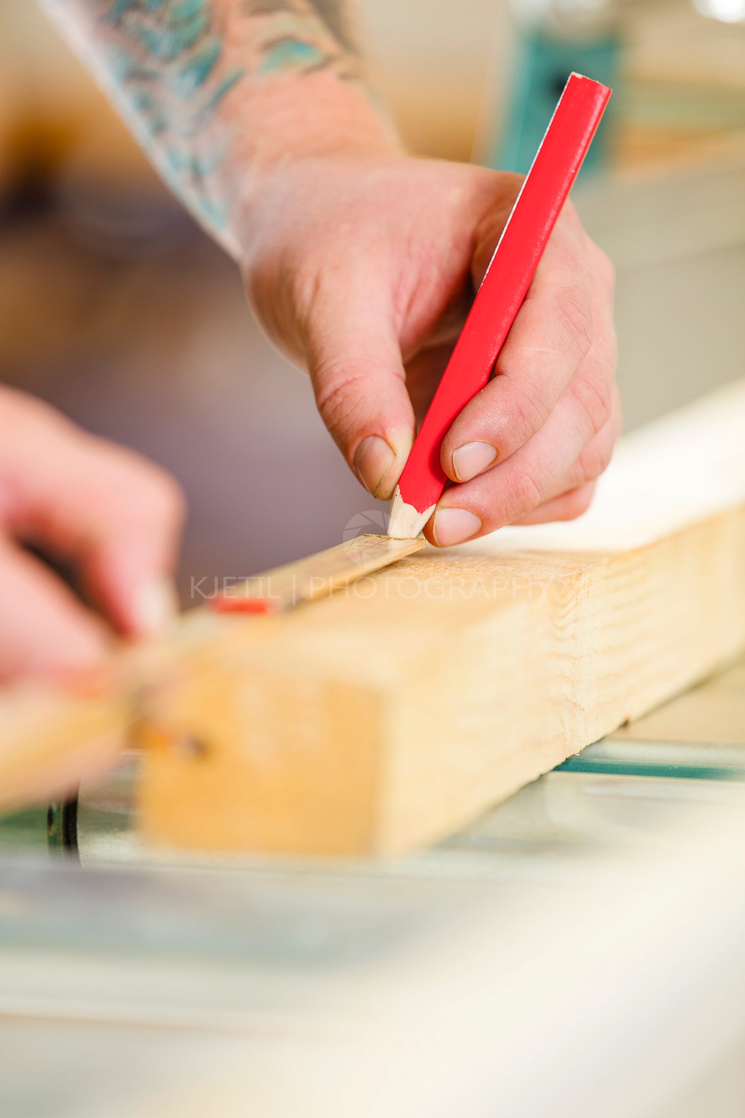 Carpenter measures the length of a wood plank before sawing
