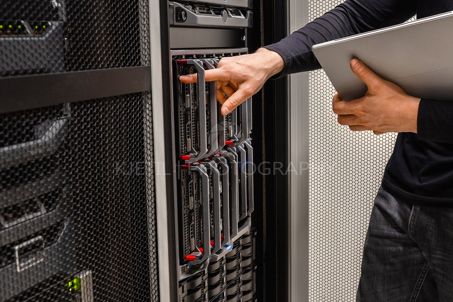 IT Professional Holding Digital Tablet Checking Blade Servers in Datacenter