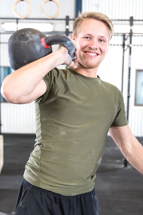 Smiling man with kettlebell at fitness gym
