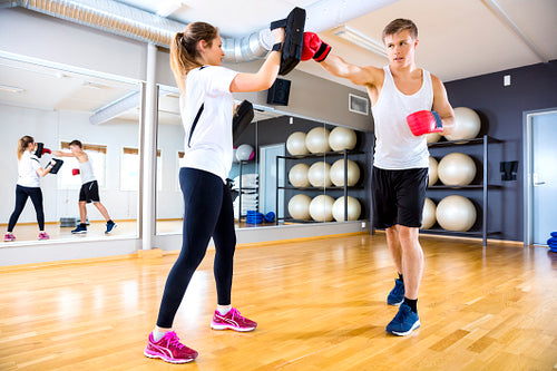 Two focused people training boxing at the fitness gym