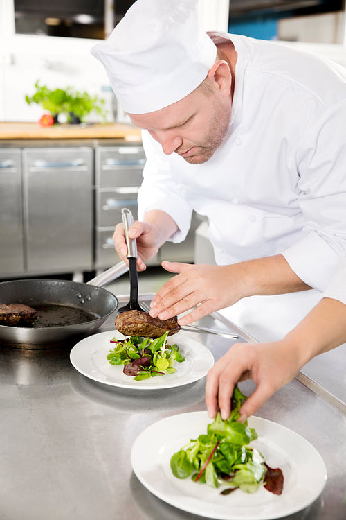 Professional chef prepare steak dish at restaurant