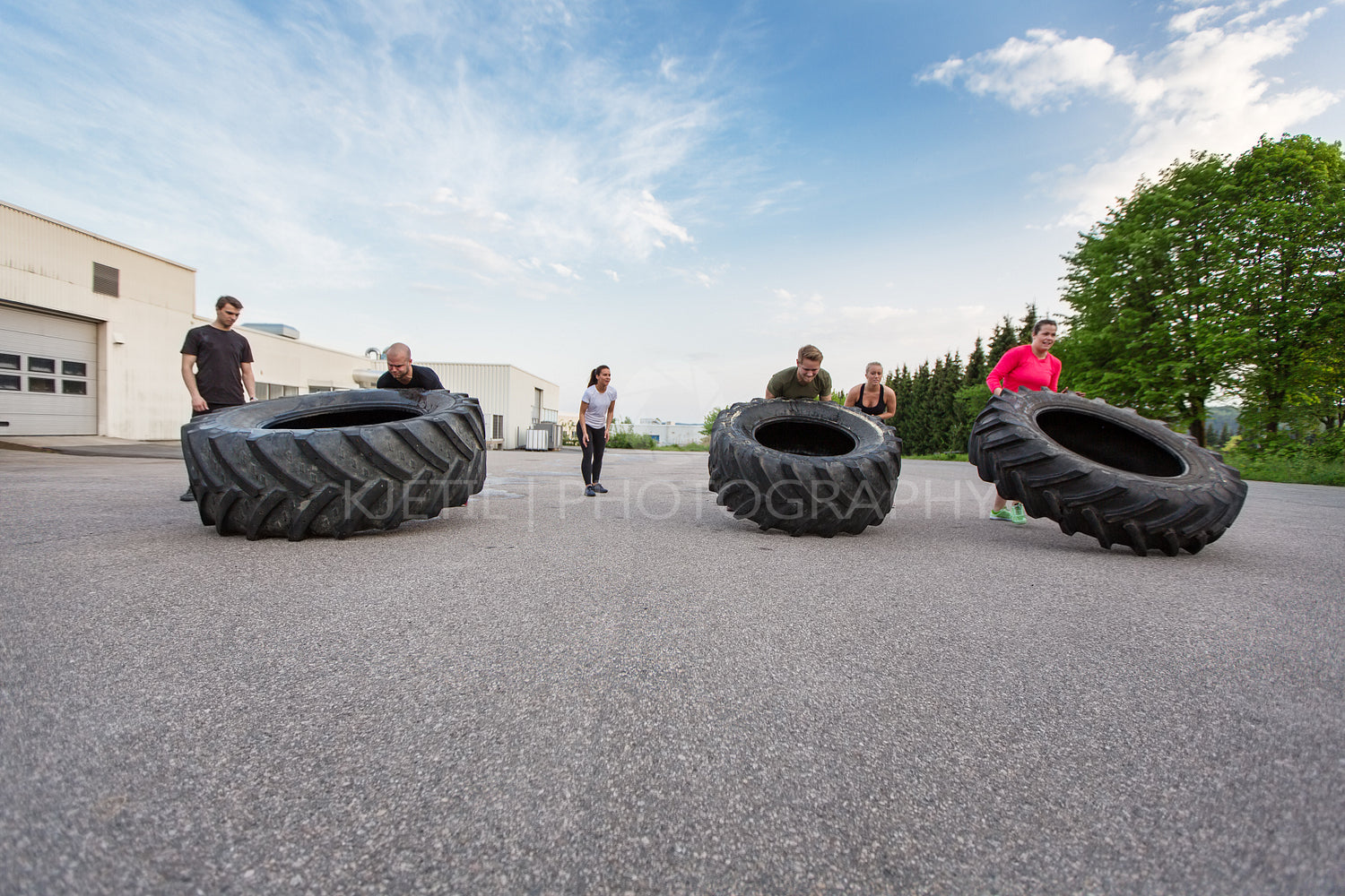 Fitness team flipping heavy tires outdoor