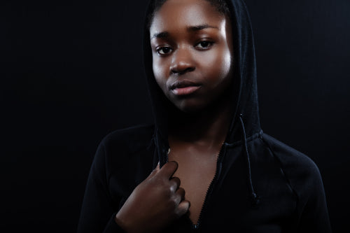 Natural woman with dark skin and attitude wearing black hoodie