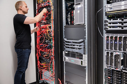 IT Technician Checking With Network Cables Connected To Servers