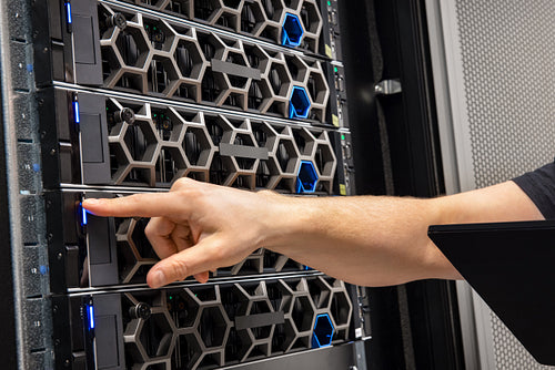Hand Of Male Technical Consultant Examining Hardware In a Hyperconverged Datacenter Environment