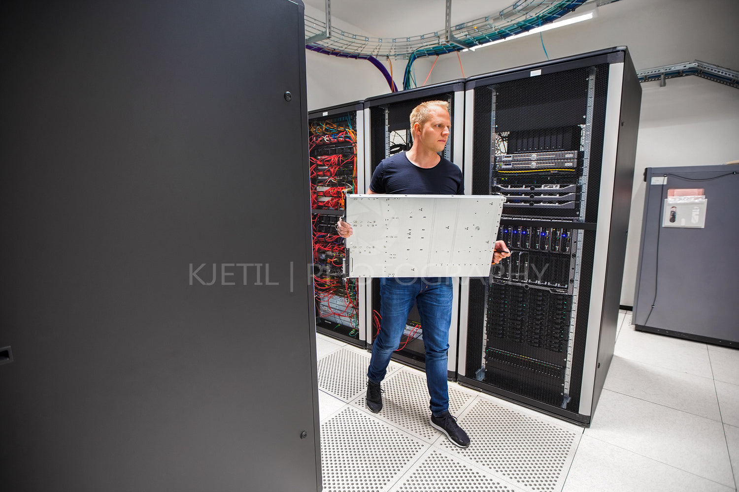 IT Consultant Carrying Blade Server While Walking In Datacenter