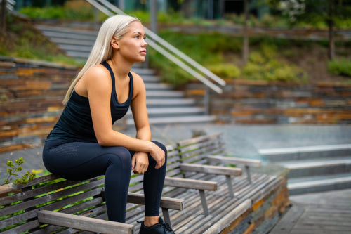 Thoughtful Runner Sitting On Bench After Workout