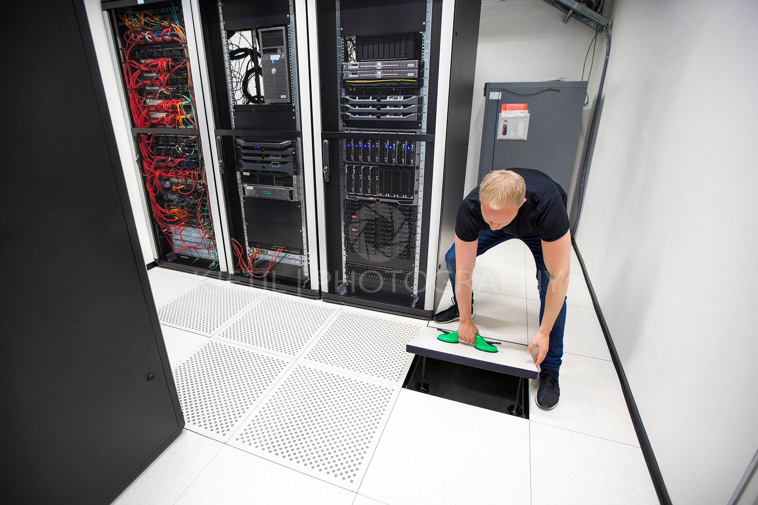 IT Engineer Lifting Floor Tile Using Suction Cups In Datacenter
