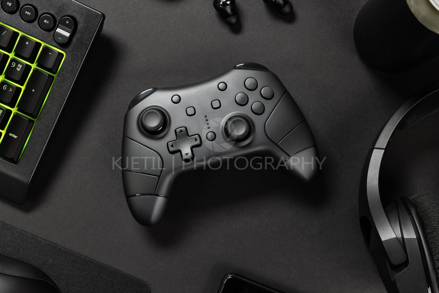 Controller with green lit keyboard amidst various wireless devices