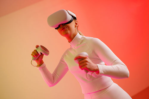 Female in VR glasses against illuminated background