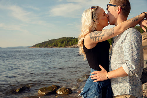 Young Blond Woman Smooching Boyfriend At Beach