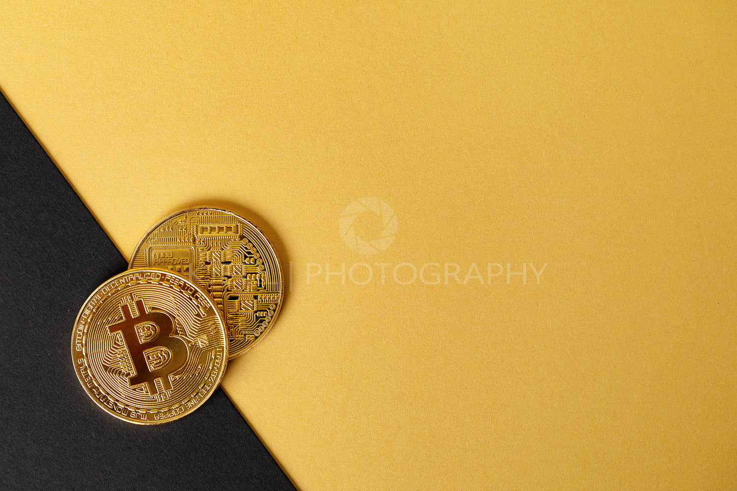 Gold bitcoin cryptocurrency coins on split gold yellow and black backgound