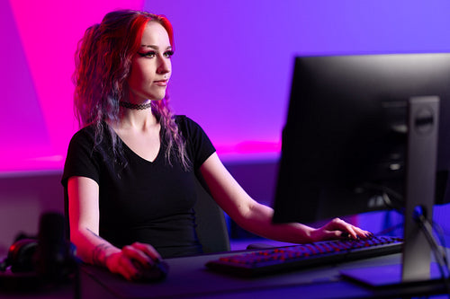 Focused Female Gamer Playing in a Vibrant Gaming Room