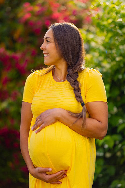 Delighted Pregnant Woman with Yellow Dress Smiling