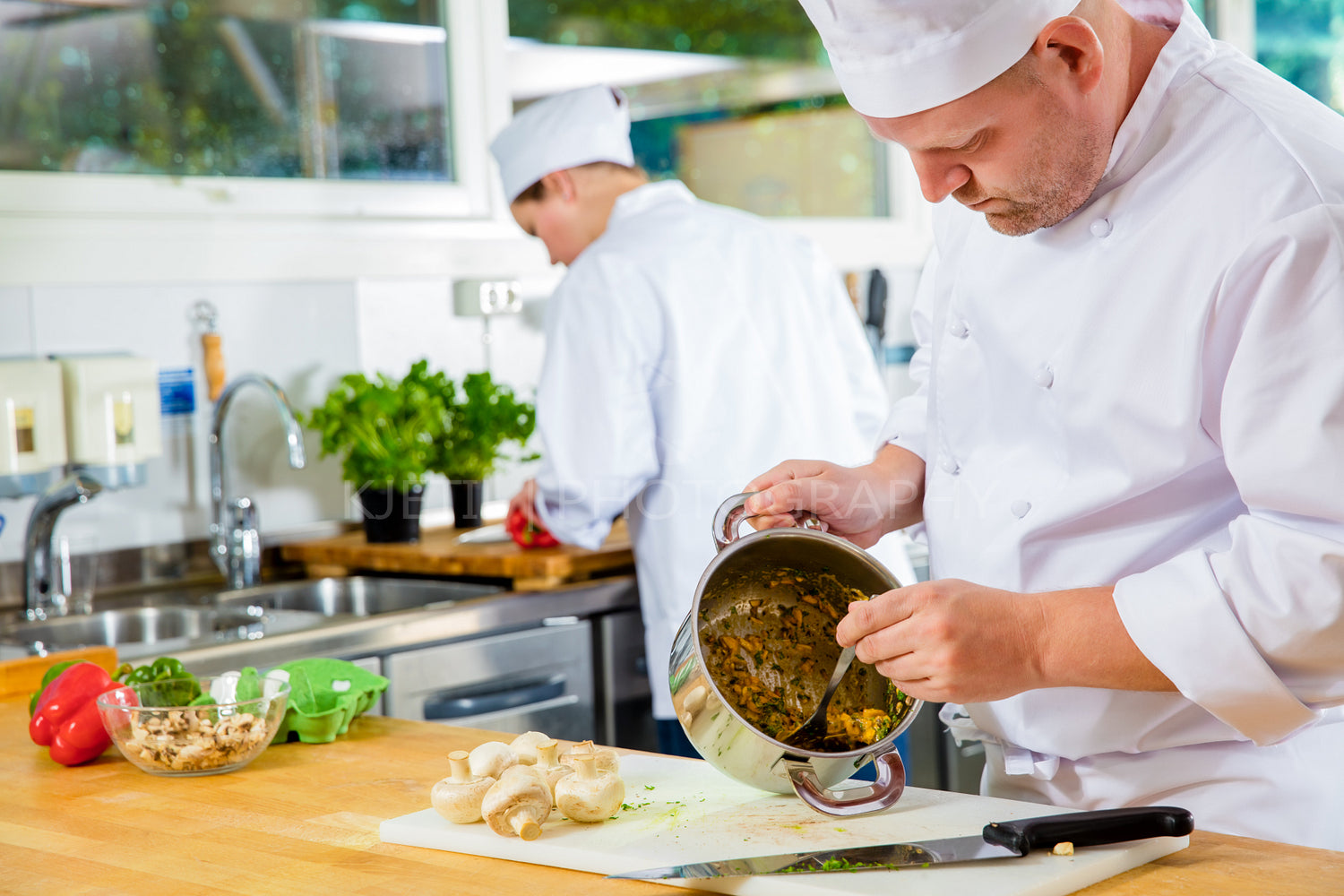 Professional chefs makes food dishes in large kitchen