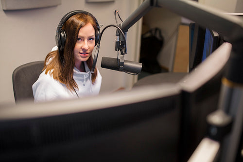 Host Wearing Headphones While Using Microphone In Radio Studio