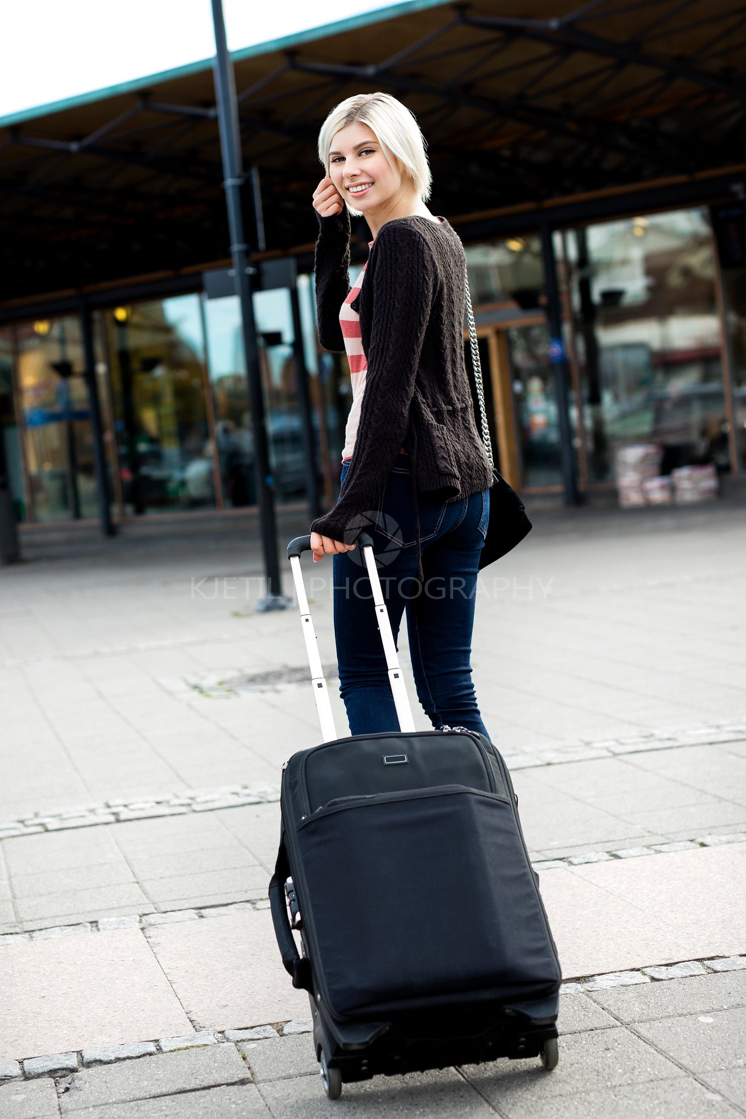 Woman With Wheeled Luggage Walking Towards Train Station