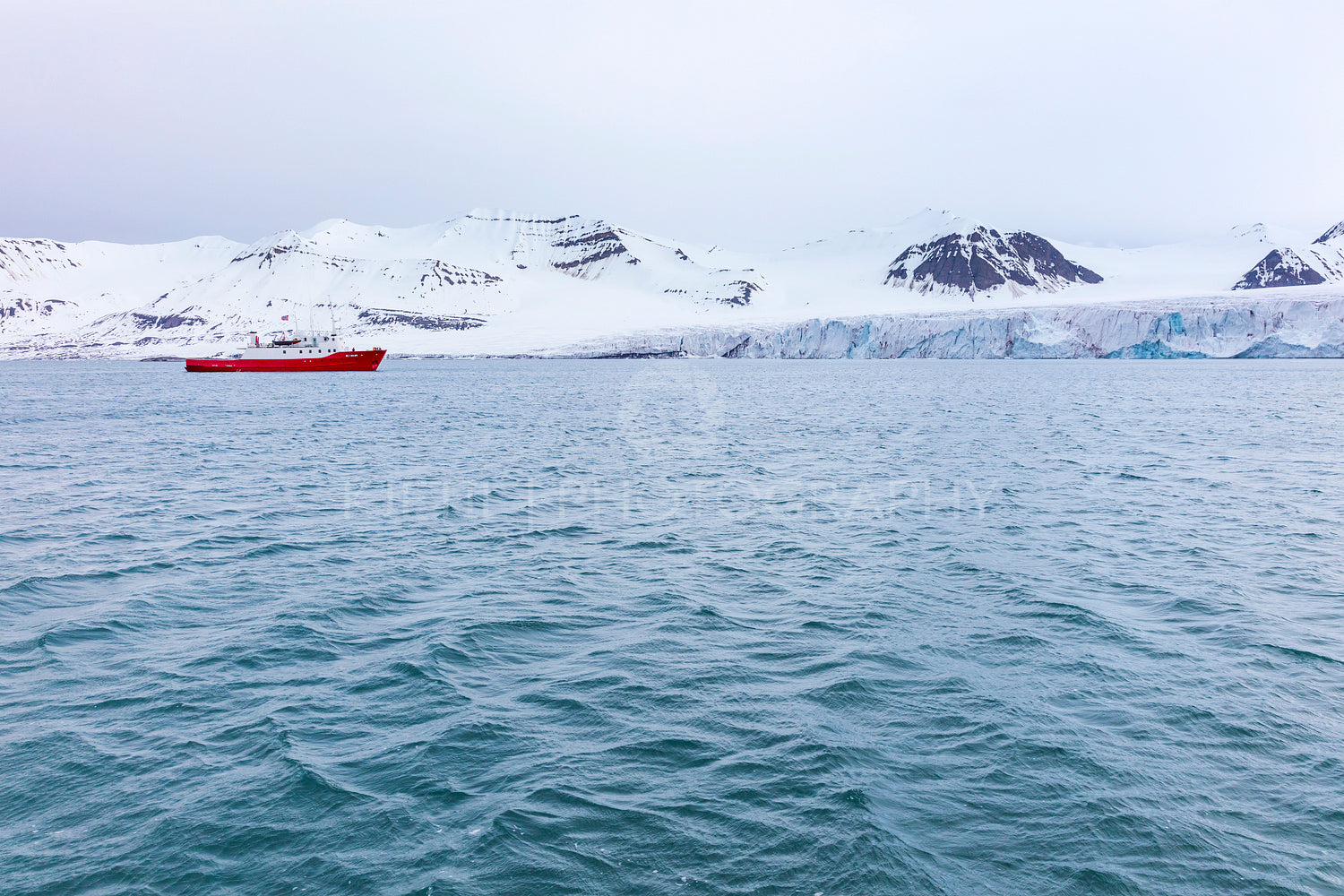 Expedition boat in front of a massive glacier